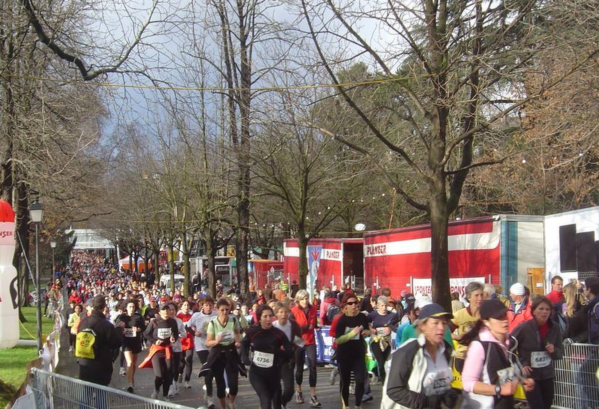 Peloton de coureurs de la Course de l'Escalade sous les arbres dénudés du parc des Bastions à Genève