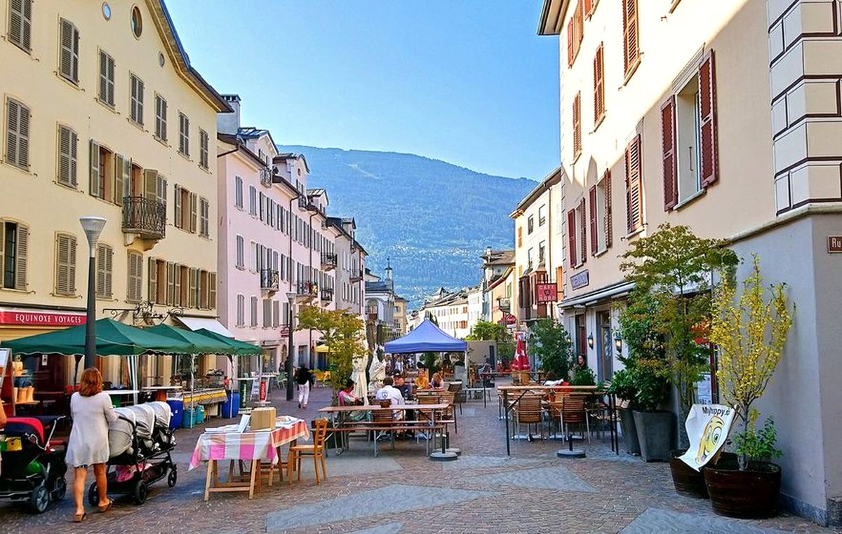 Terrasses et étals sur la rue du Grand-Pont dans la vieille ville de Sion