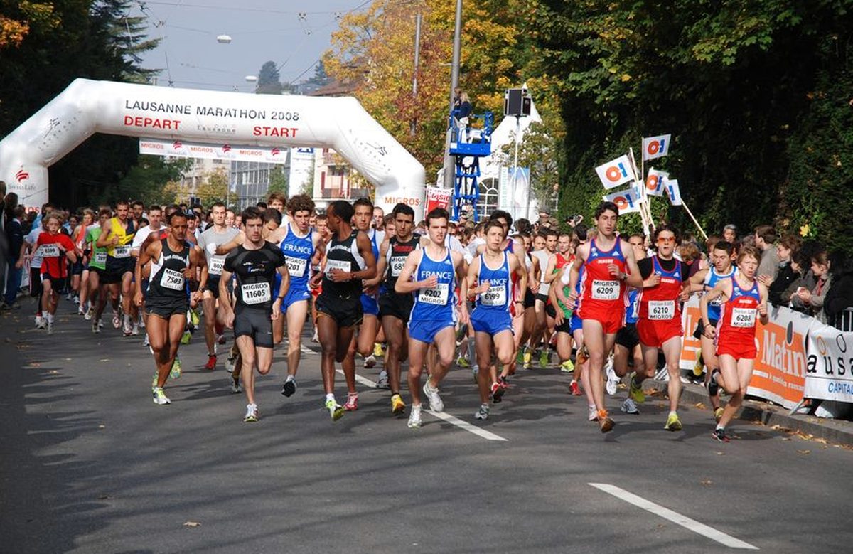 Départ du Lausanne Marathon, peloton de coureurs sous l'arche gonflable