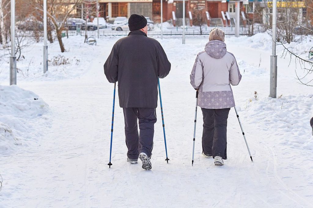 Älteres Paar beim Nordic Walking im Schnee