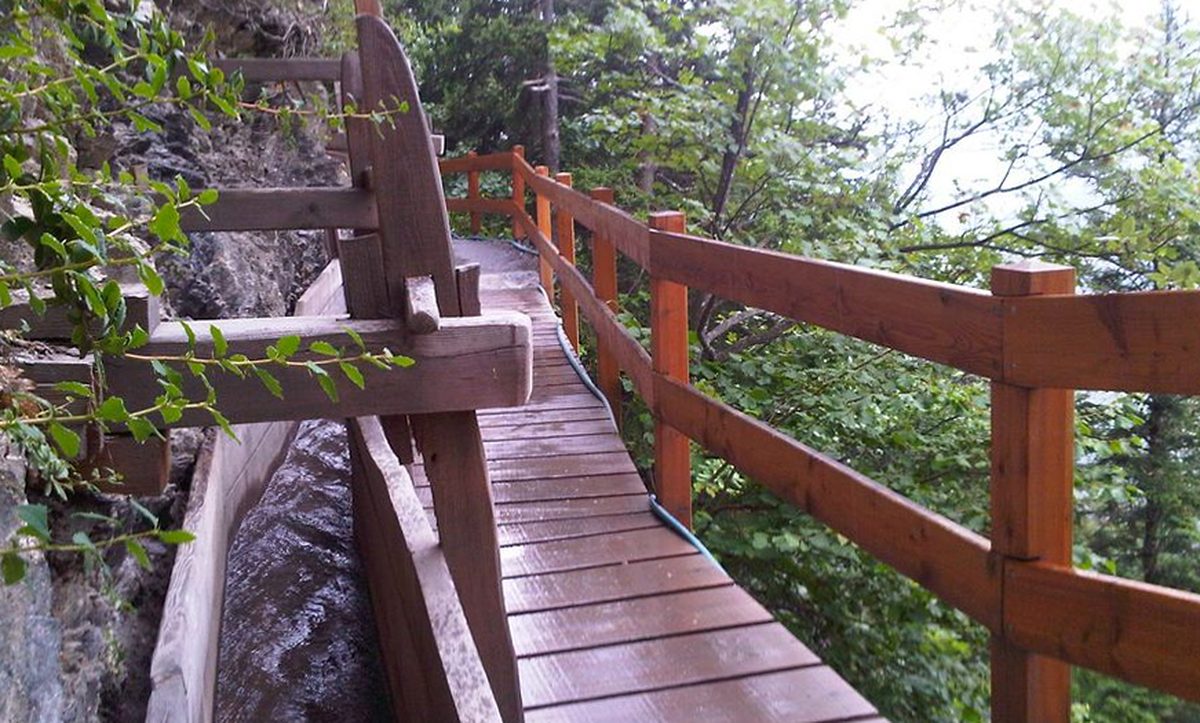 Passerelle en bois du bisse du Torrent-Neuf longeant la paroi rocheuse à Savièse