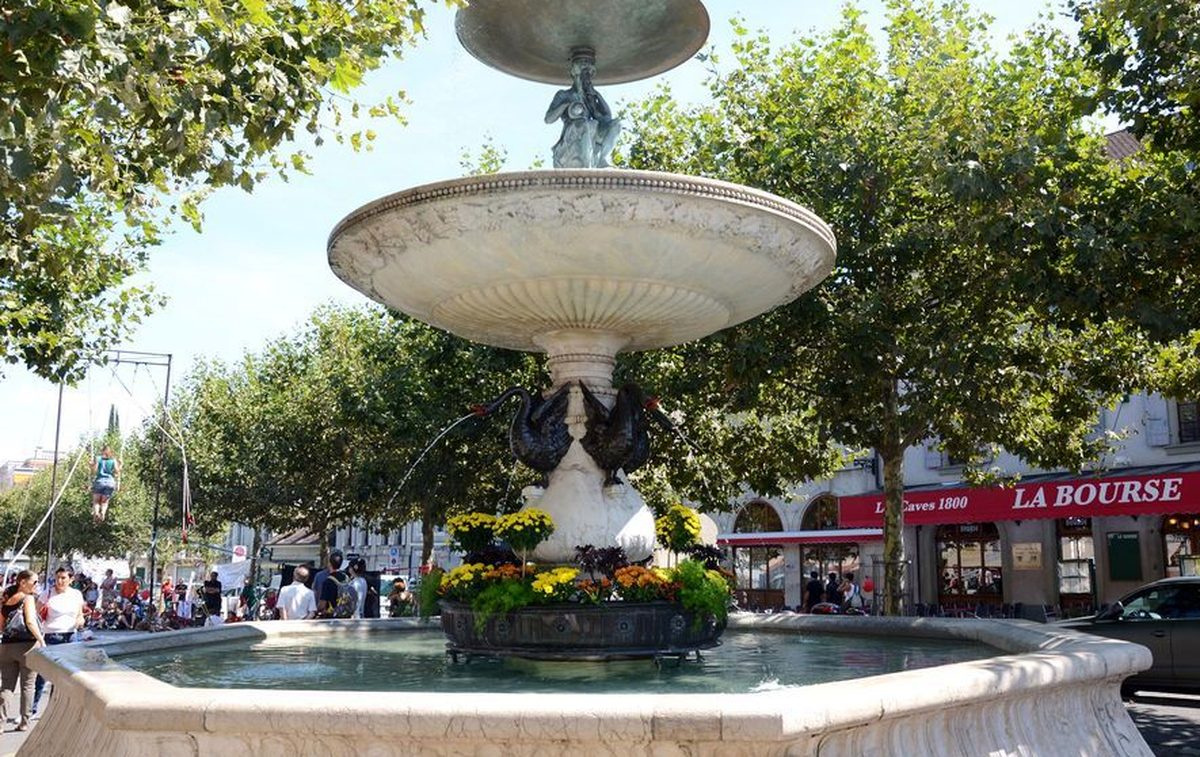 Fontaine à vasques de la place du Marché à Carouge sous les platanes, terrasse du café La Bourse en arrière-plan